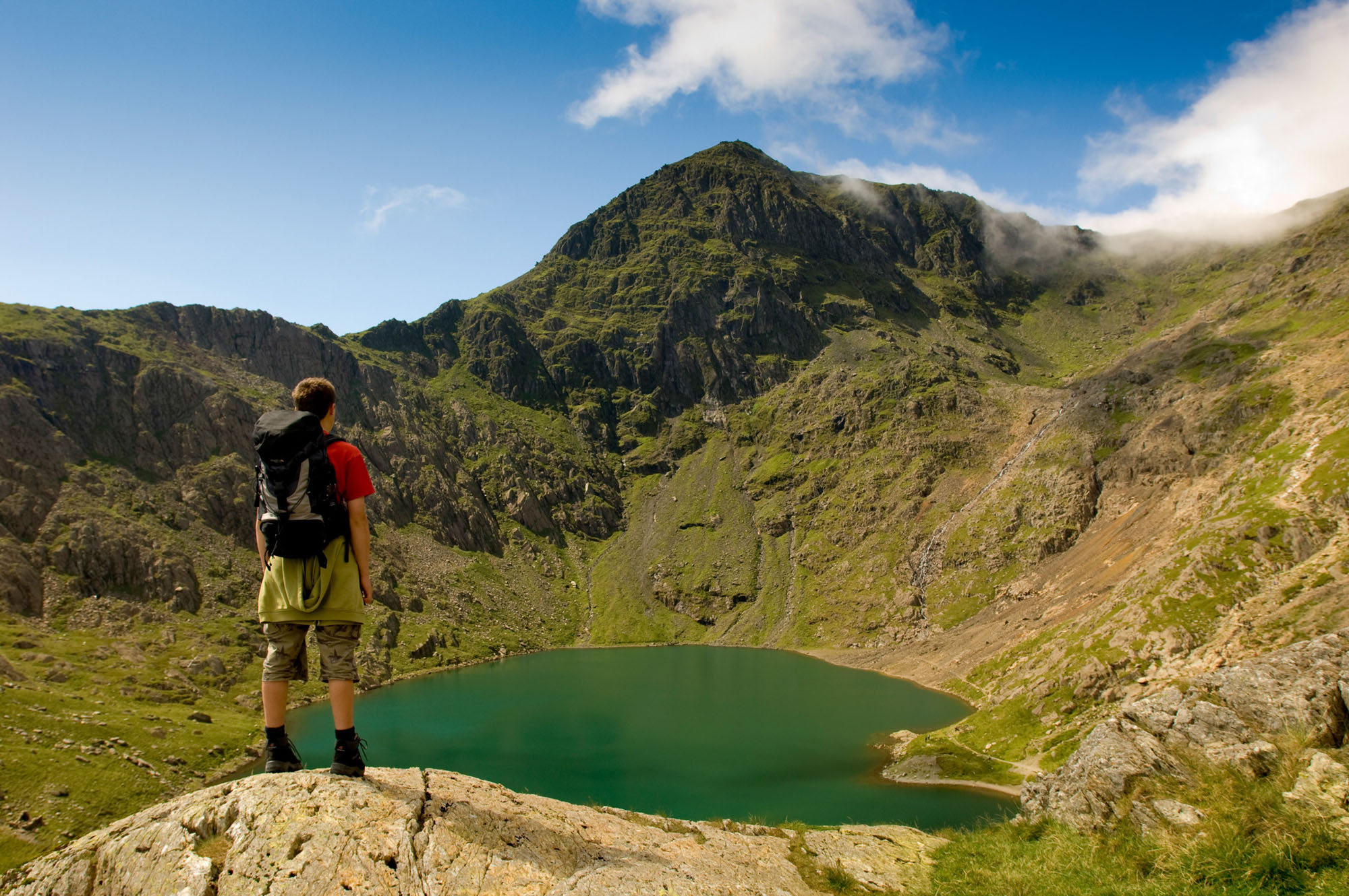 Hiker overlooking lake demonstrating scale and grandeur of the landscape.