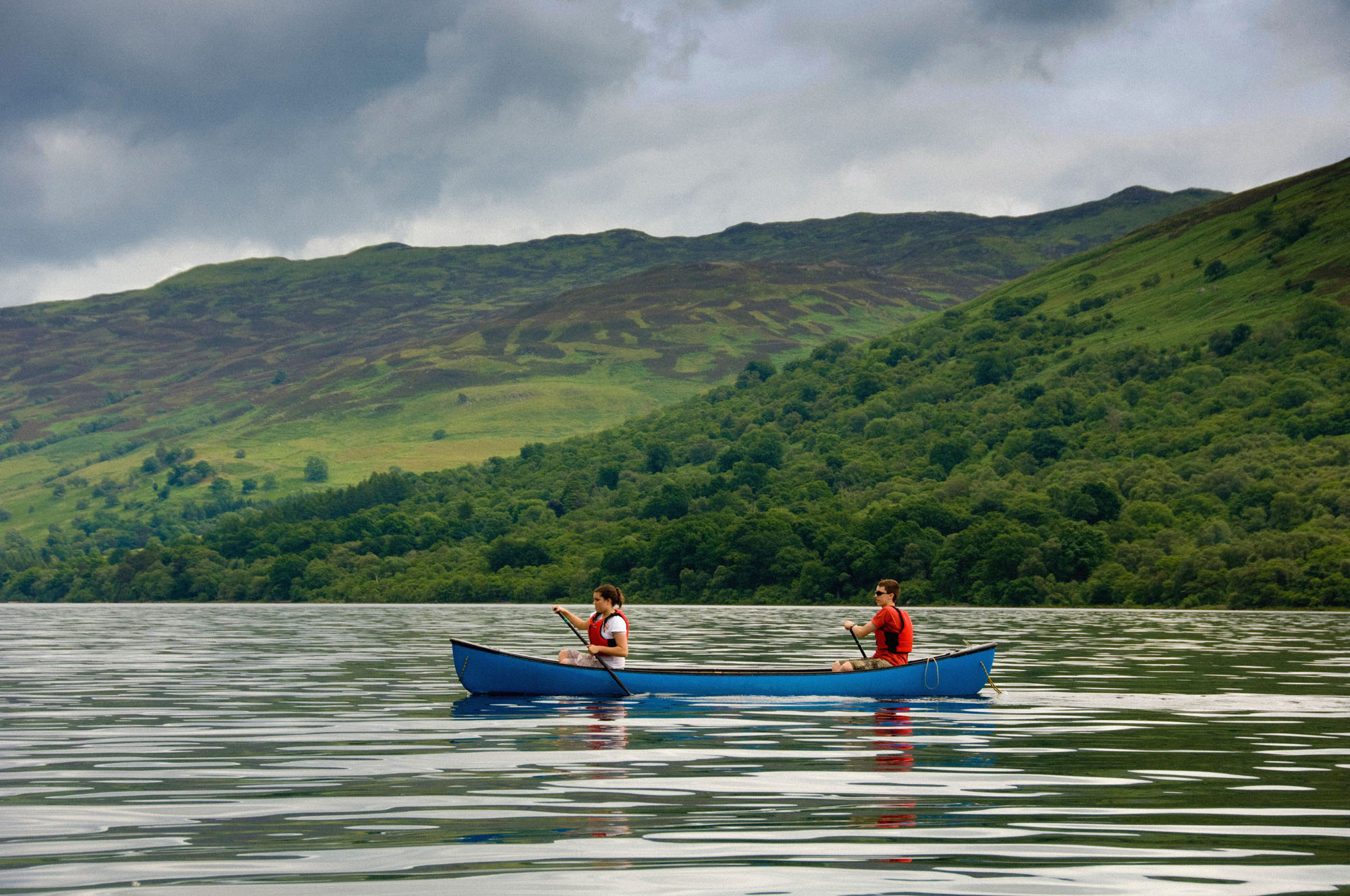 Young adults in a canoe give a sense of scale to the landscape.